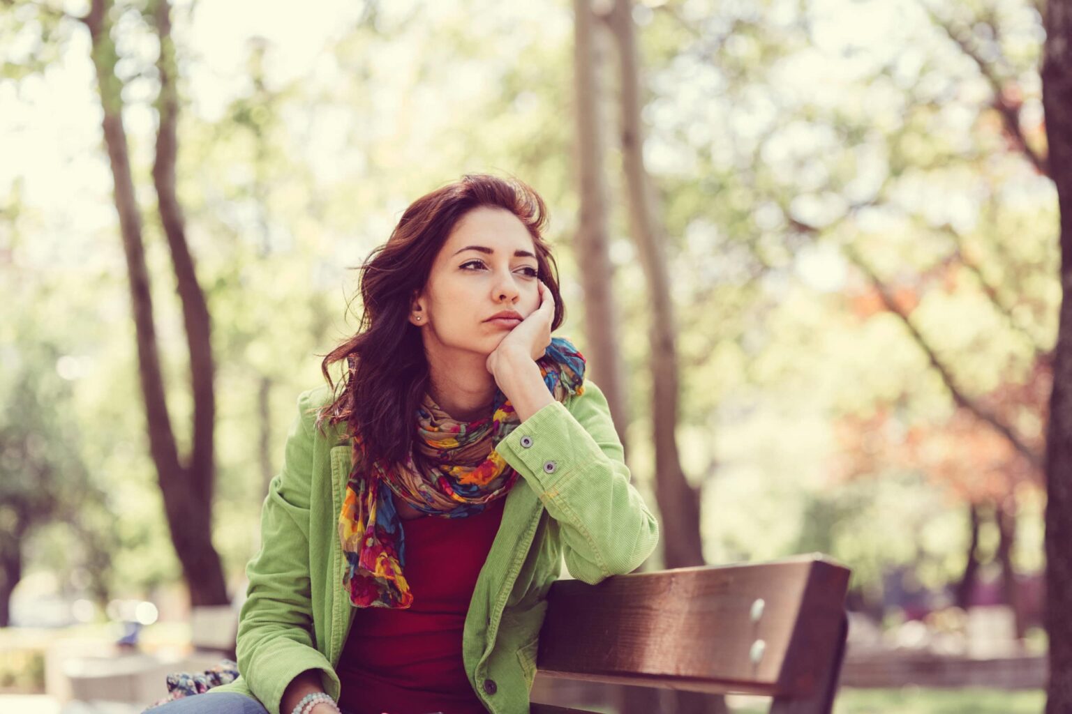 Woman pondering on a bench