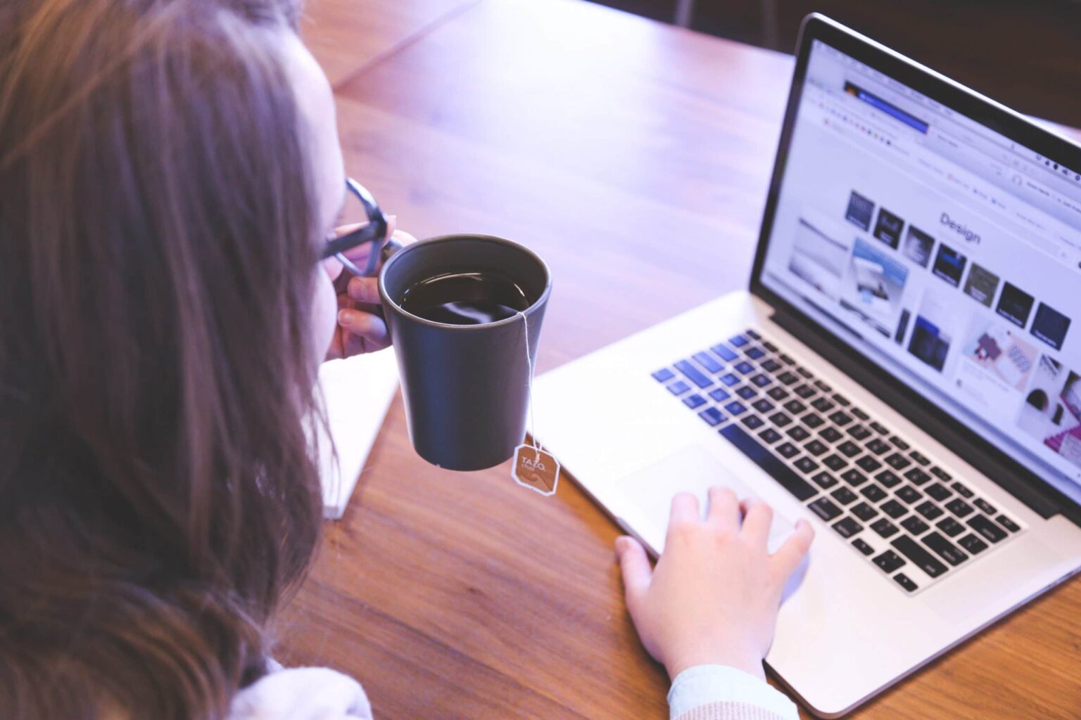 woman with a tea cup using a laptop