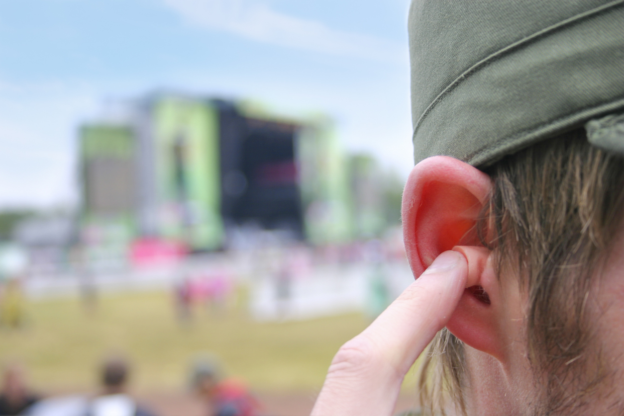 Person at a sports event wearing hearing protection to prevent hearing loss.