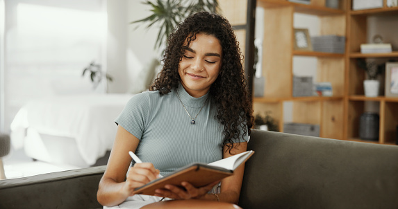 Woman writing in a notebook, making plans and taking notes.